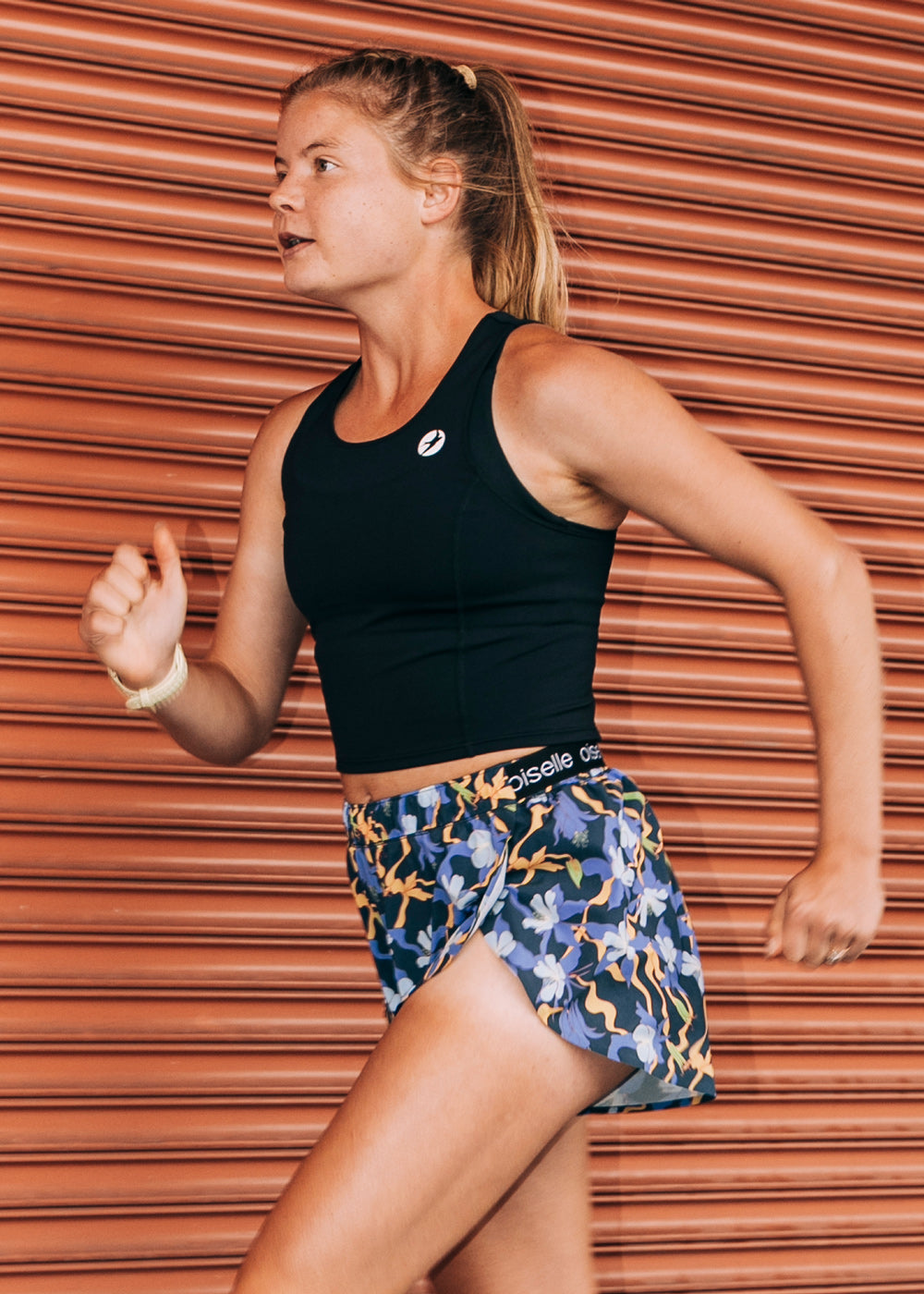 Woman running outside in Oiselle split shorts and Race day crop